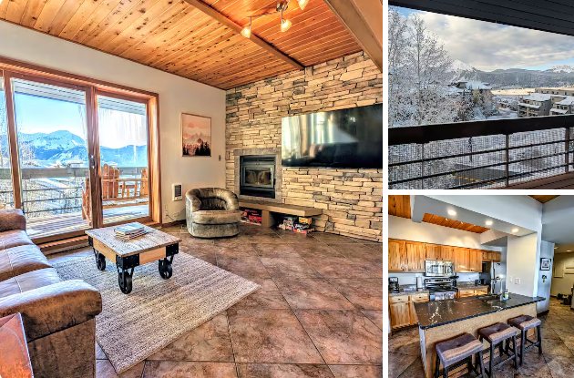 Mountain Condo living room with stone fireplace, snowy mountain view from the balcony, and kitchen